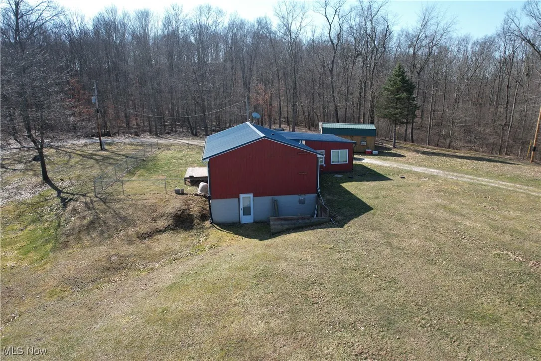 Birds eye view of property with a wooded view