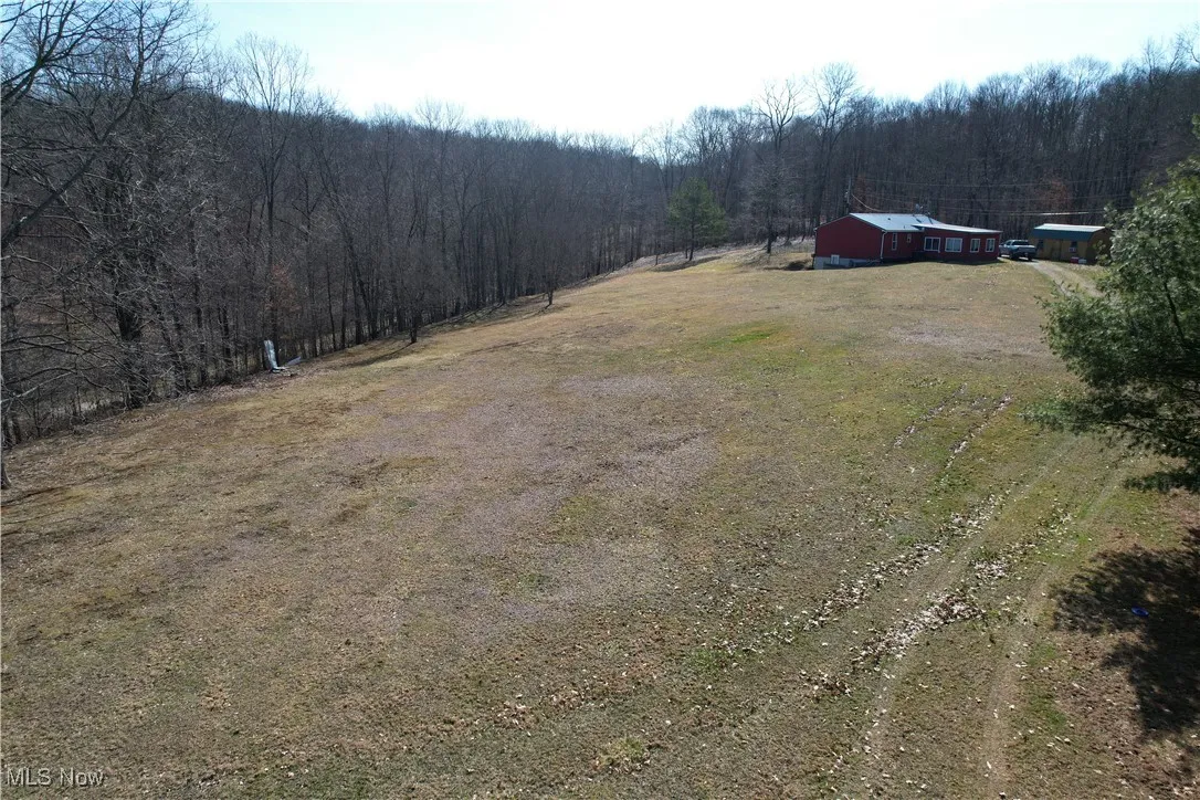 View of yard with an outbuilding, a rural view, driveway, and a view of trees
