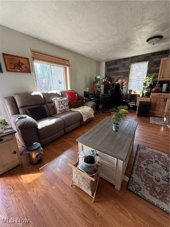 Living room featuring a textured ceiling and wood finished floors