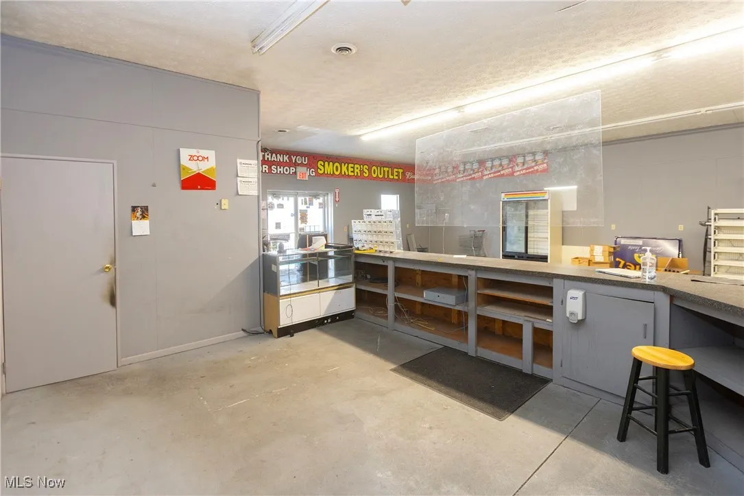 Misc room featuring visible vents, a workshop area, and concrete flooring