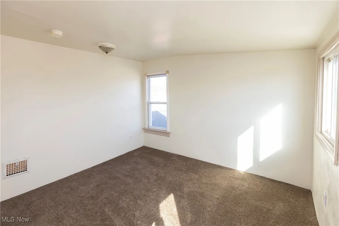 Carpeted spare room with visible vents