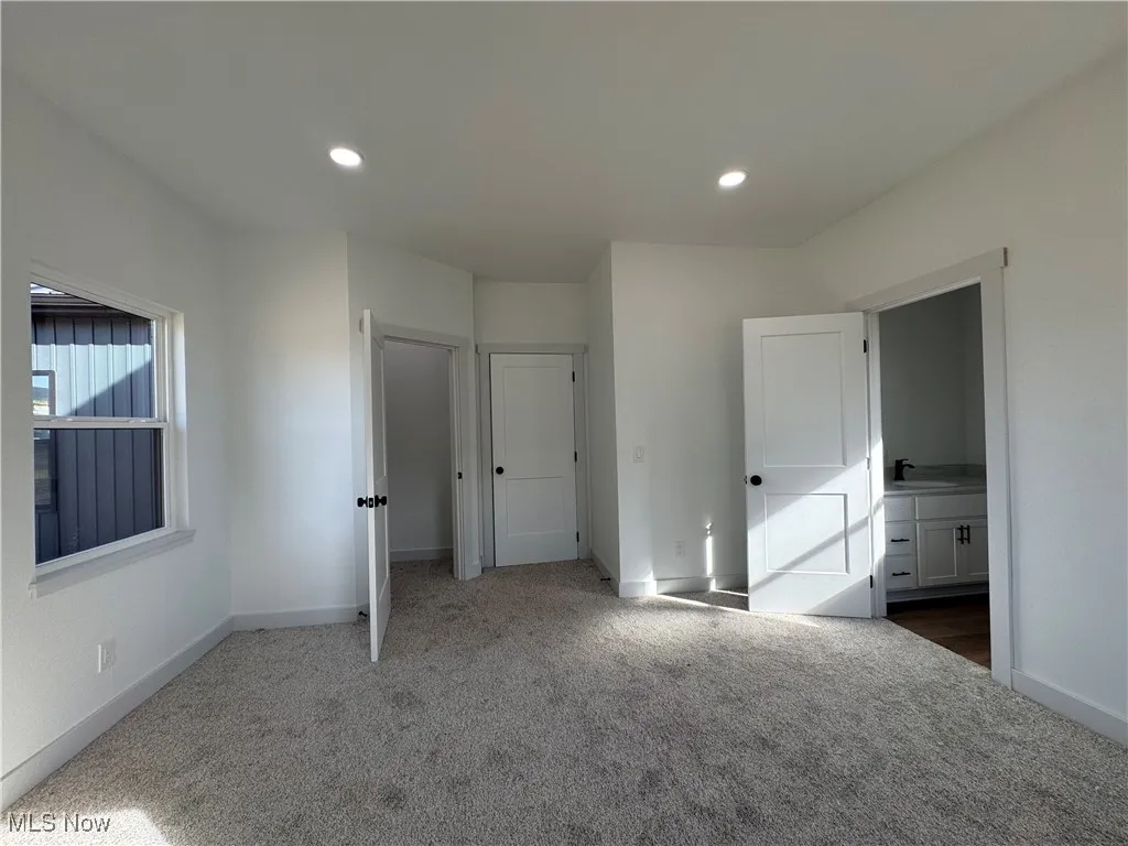 Unfurnished bedroom with carpet and recessed lighting