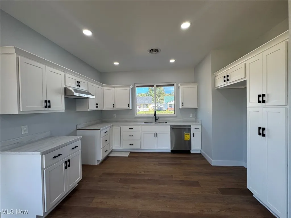 Kitchen with white cabinets, light countertops, recessed lighting, and dark wood-style floors