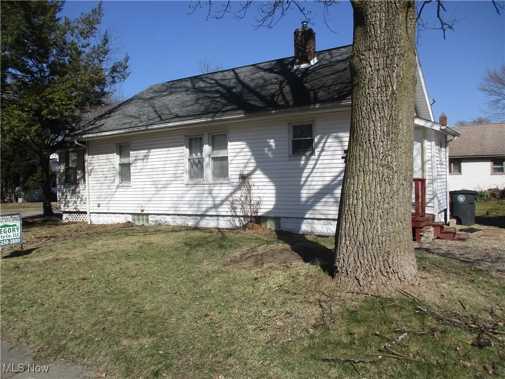 View of side of property with a lawn and a chimney