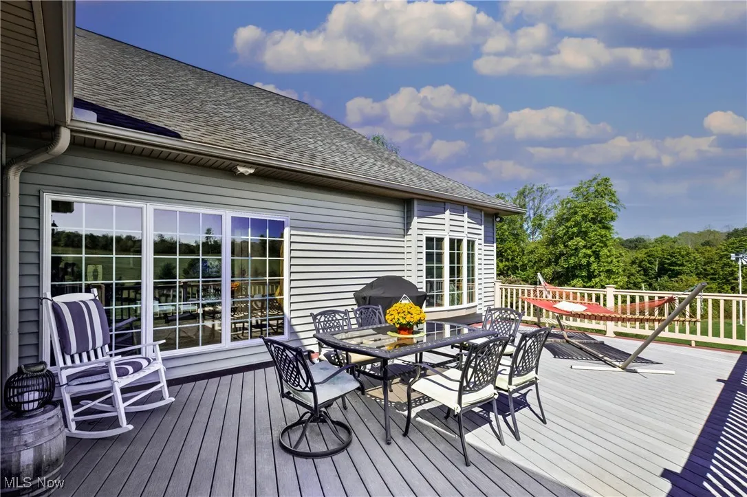 Wooden terrace featuring grilling area and outdoor dining area