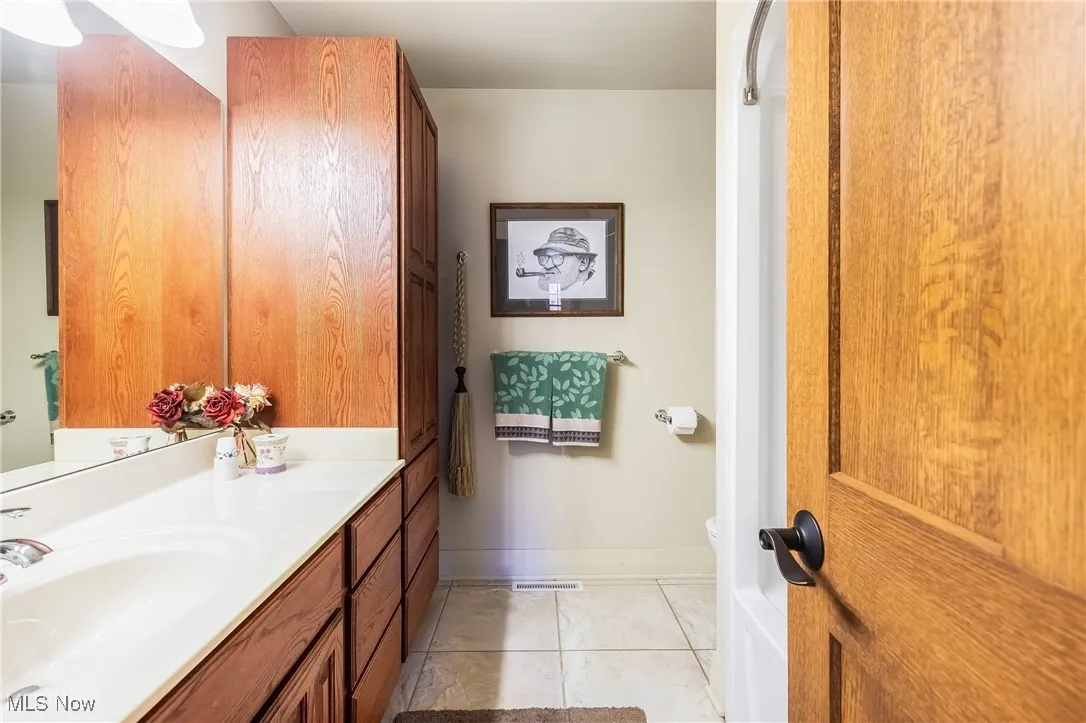 Bathroom with baseboards, toilet, vanity