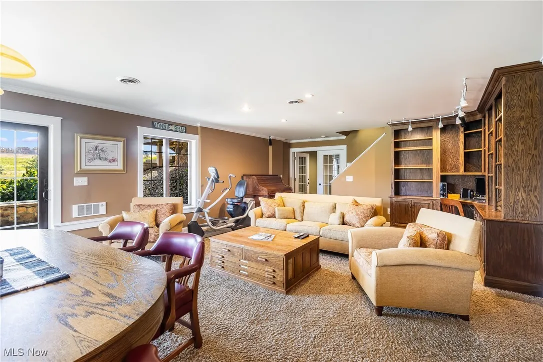 Carpeted living room with recessed lighting, a healthy amount of sunlight, crown molding, and visible vents