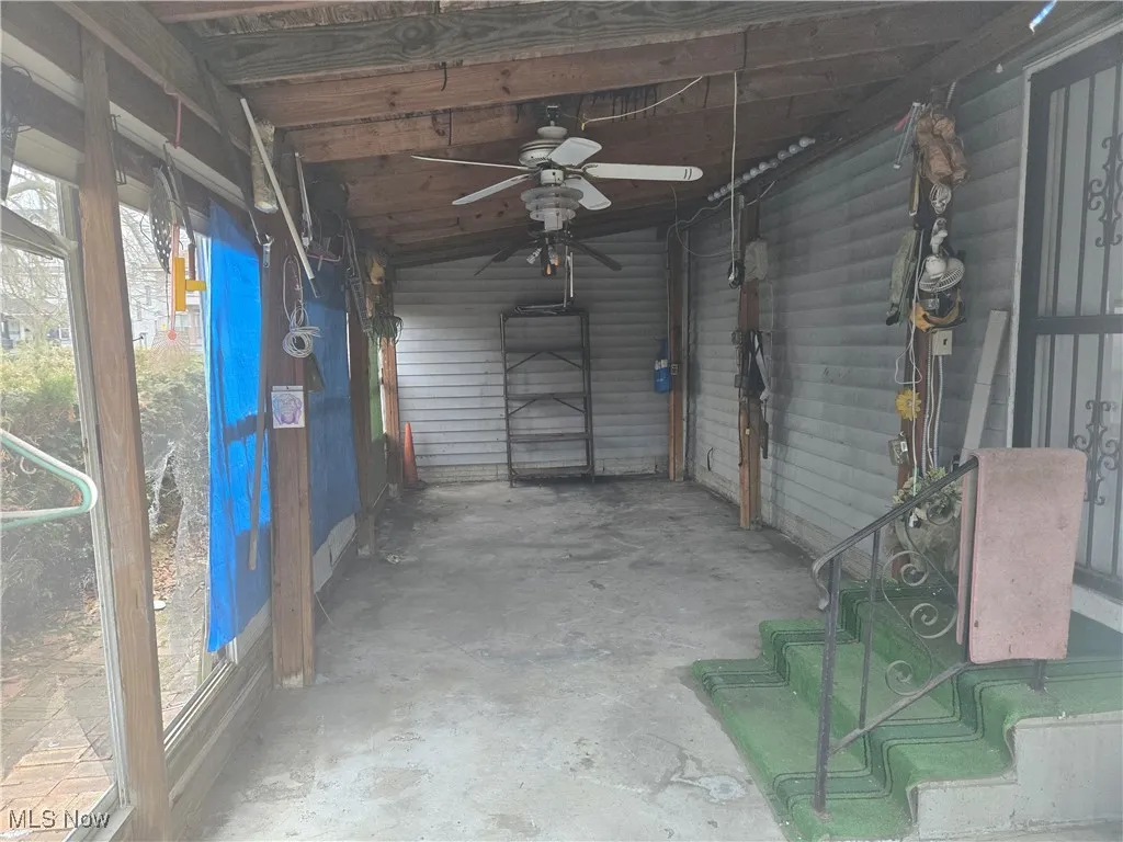 Unfurnished sunroom featuring a ceiling fan