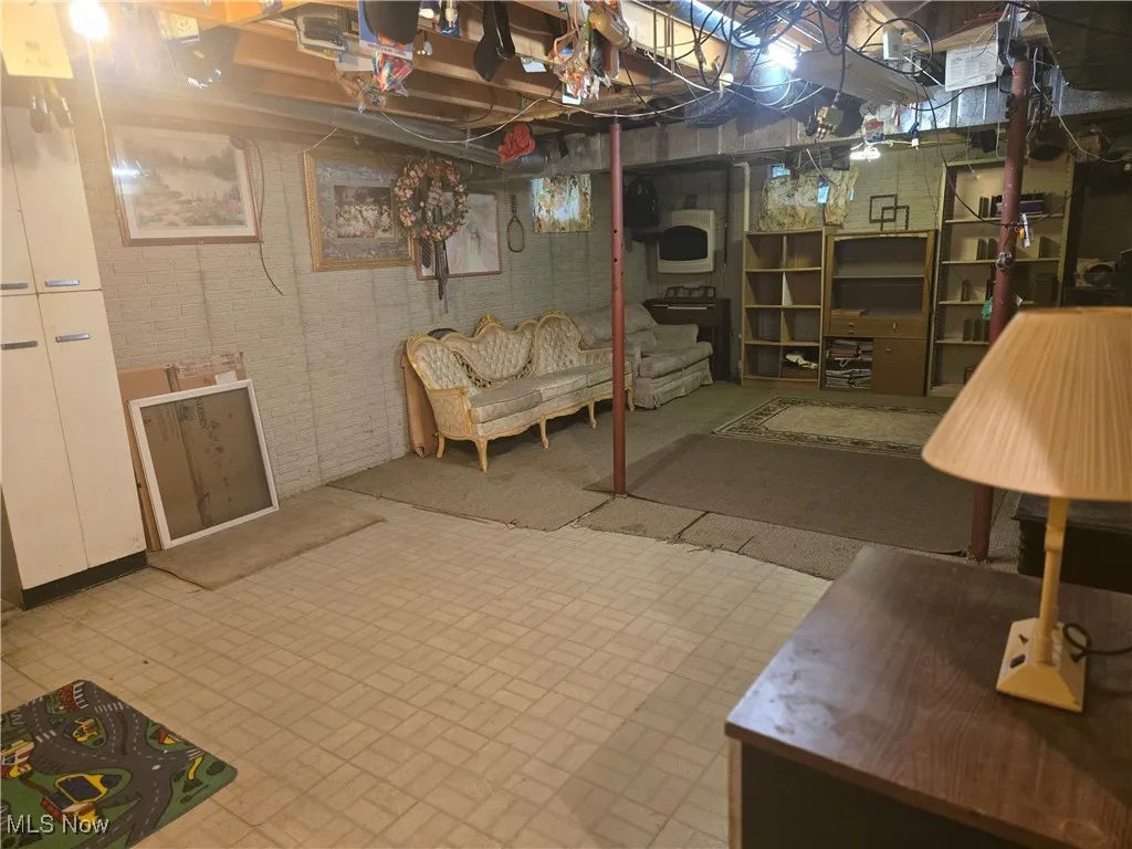 Unfinished basement featuring brick wall