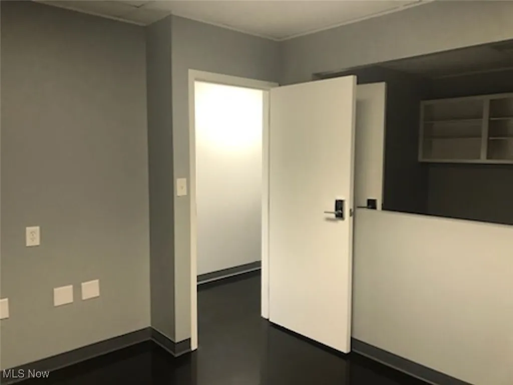 Unfurnished room featuring finished concrete flooring