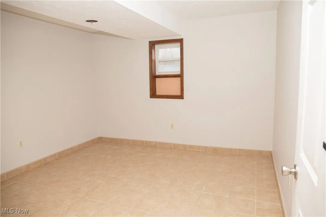 Unfurnished room with baseboards and a textured ceiling