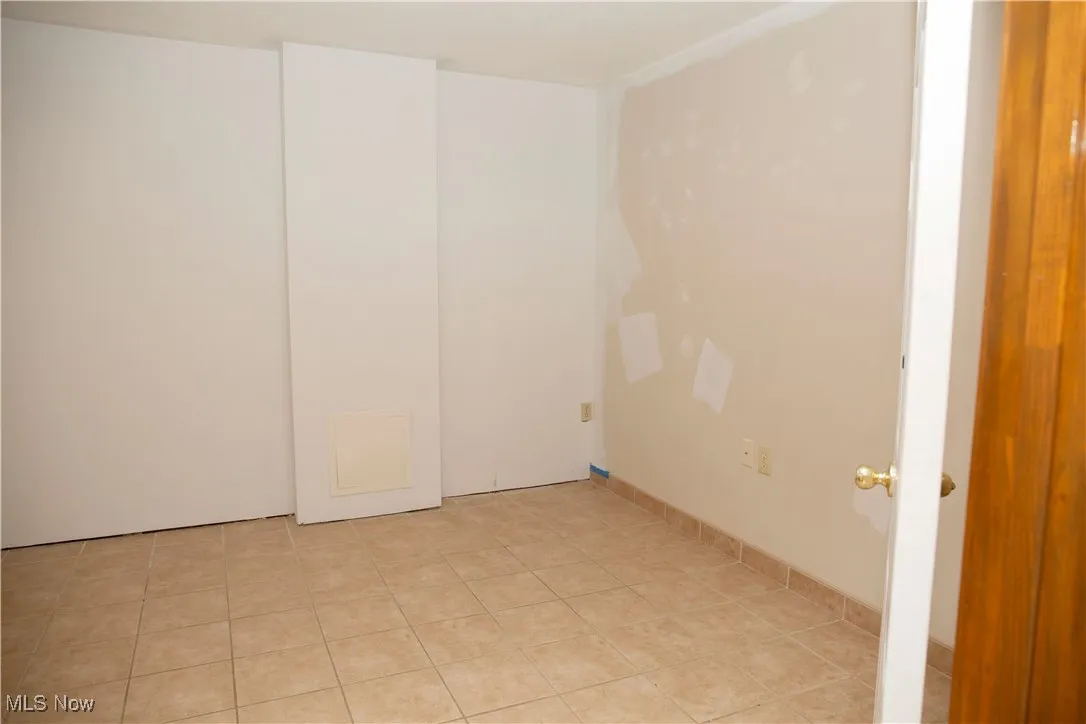 Empty room with light tile patterned flooring