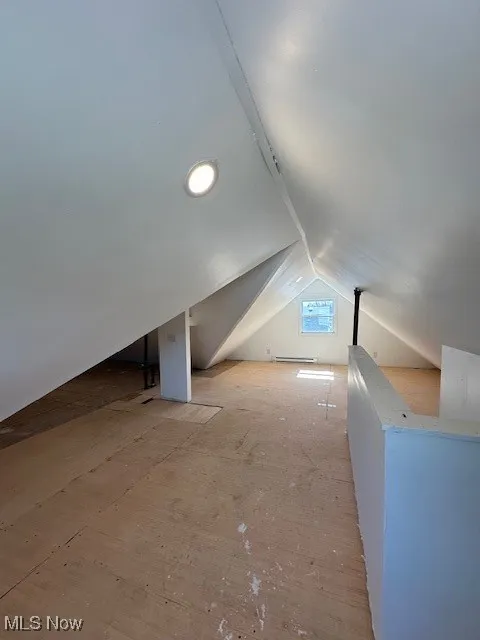 Bonus room featuring a baseboard heating unit and vaulted ceiling