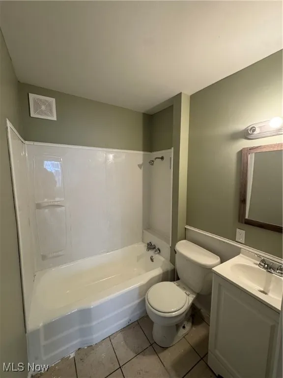 Bathroom with visible vents, toilet,  shower combination, tile patterned flooring, and vanity