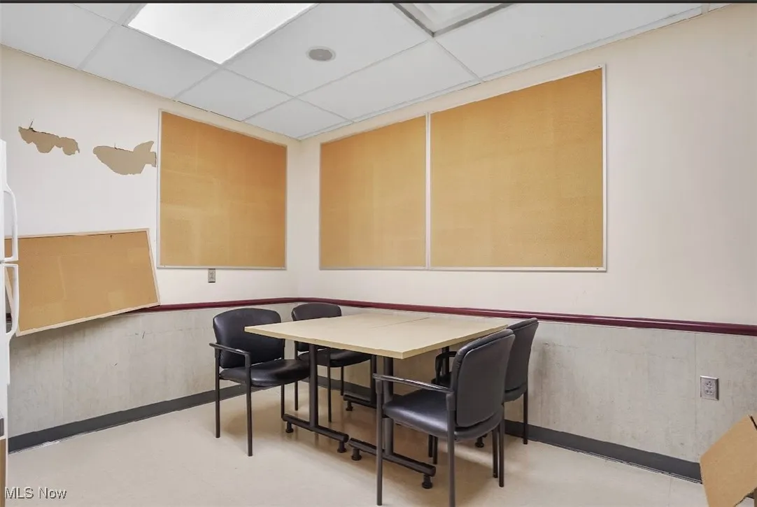 Dining room featuring wainscoting and a paneled ceiling