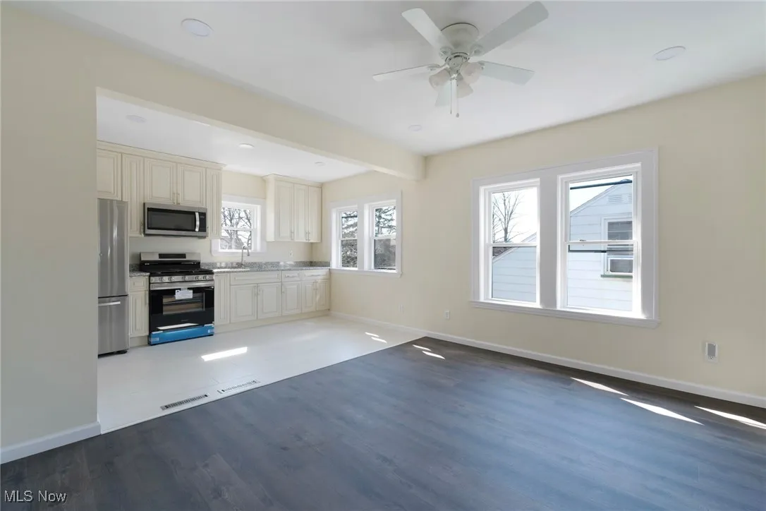 Kitchen featuring stainless steel appliances, baseboards, and cream cabinetry