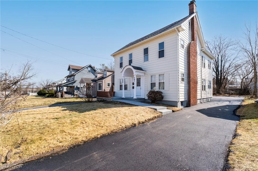 View of front of home featuring a chimney and a front lawn