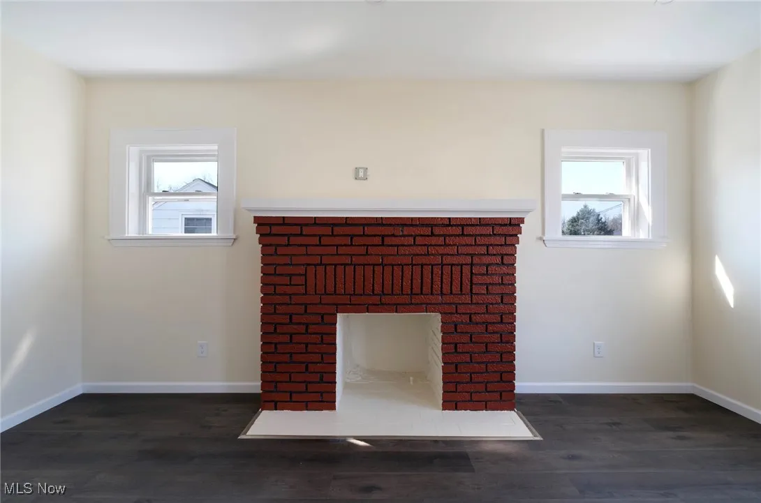 Details with baseboards, wood finished floors, and a fireplace