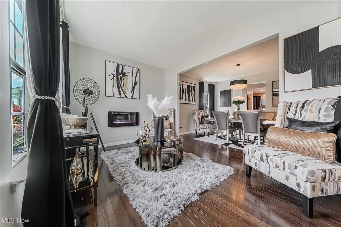 Living room featuring dark wood finished floors and baseboards