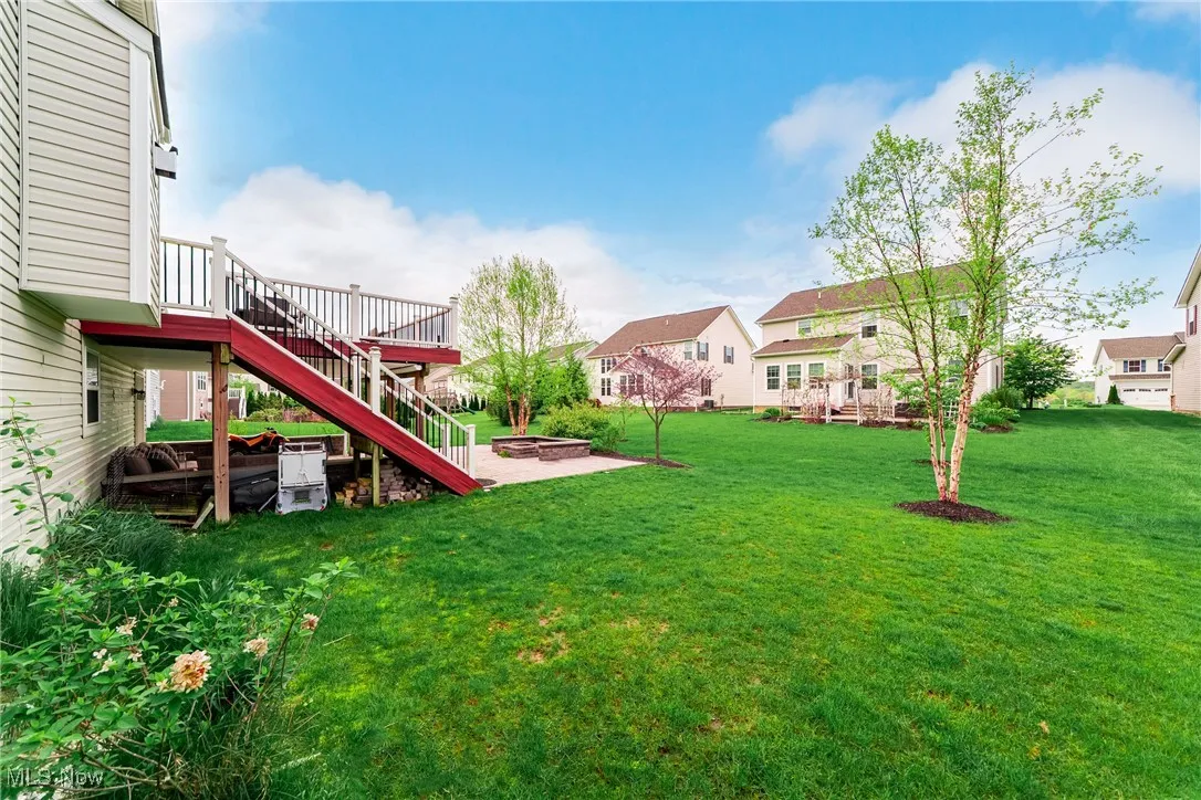 View of yard featuring a residential view, a deck, stairway, and a fire pit