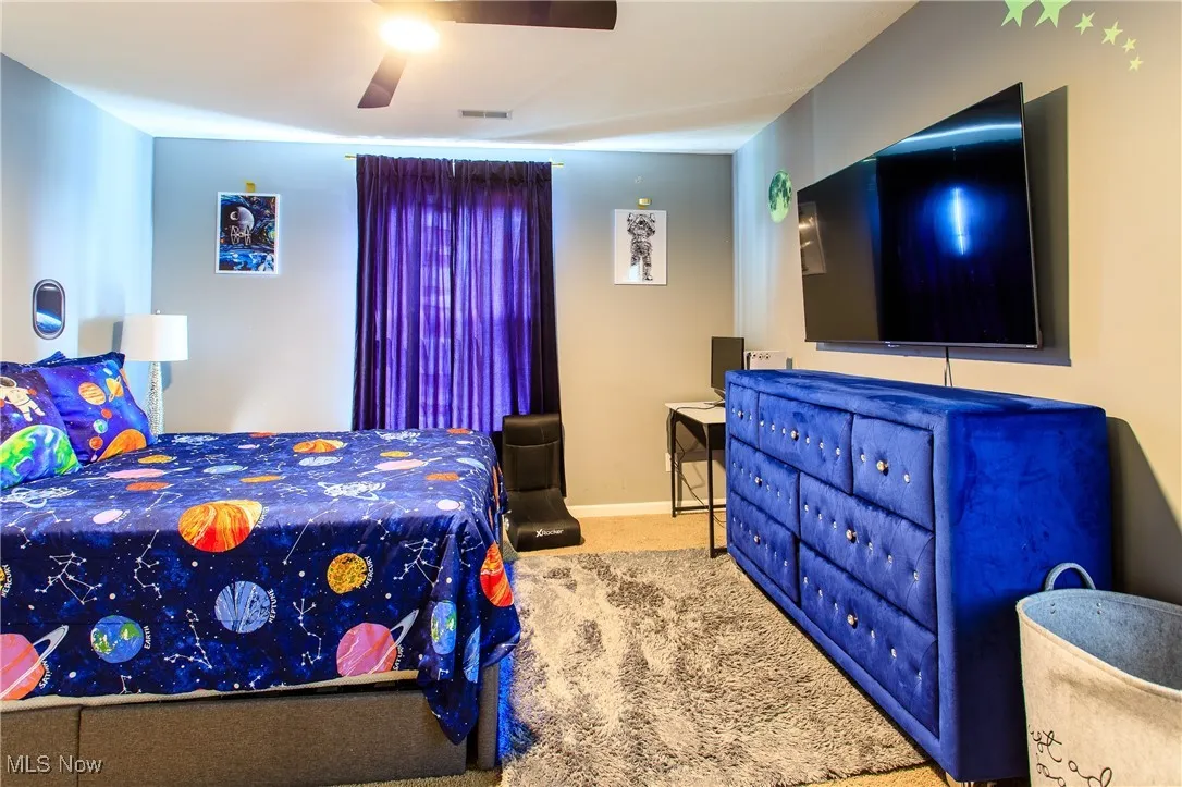 Bedroom featuring carpet, a ceiling fan, and baseboards