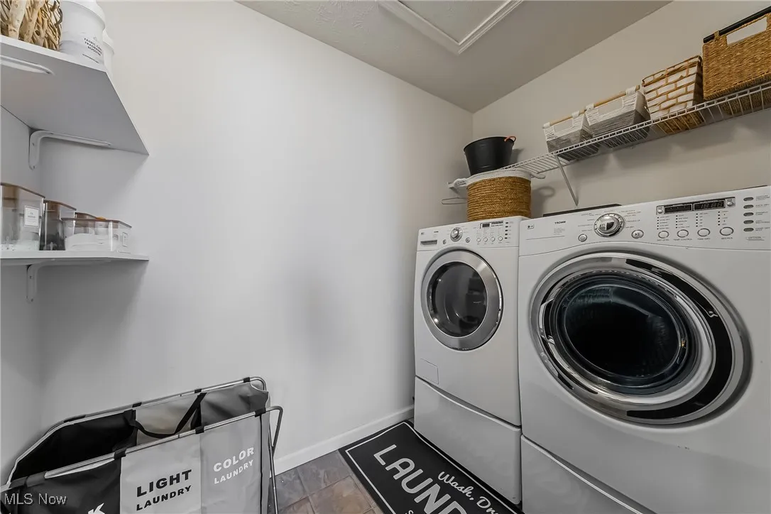 Clothes washing area with laundry area, independent washer and dryer, and baseboards