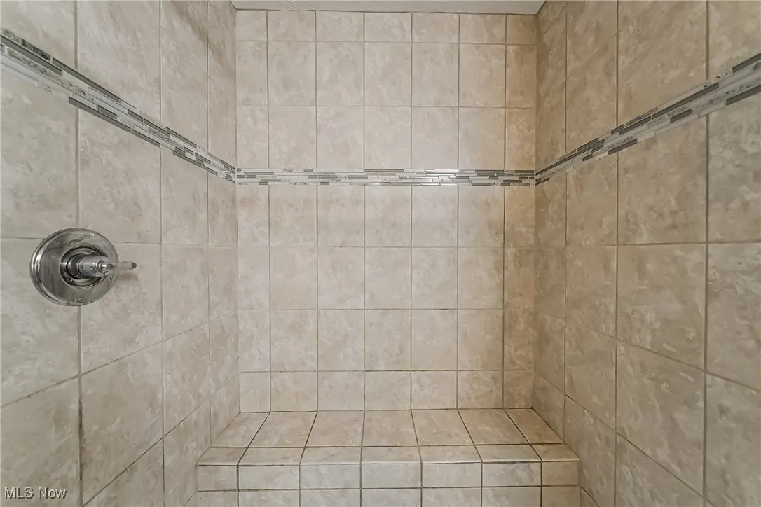 Full bath featuring tiled shower
