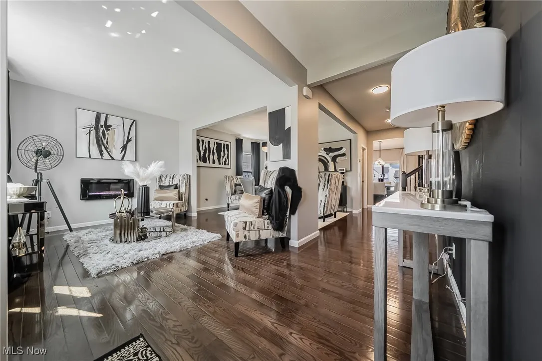 Living room with recessed lighting, baseboards, lofted ceiling with beams, and dark wood-style floors