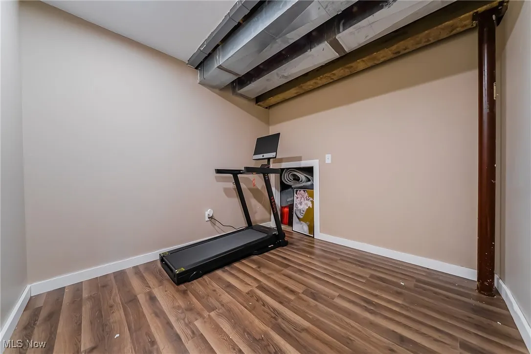 Workout area featuring baseboards and wood finished floors