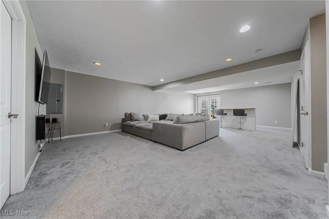 Living area featuring carpet flooring, baseboards, and recessed lighting