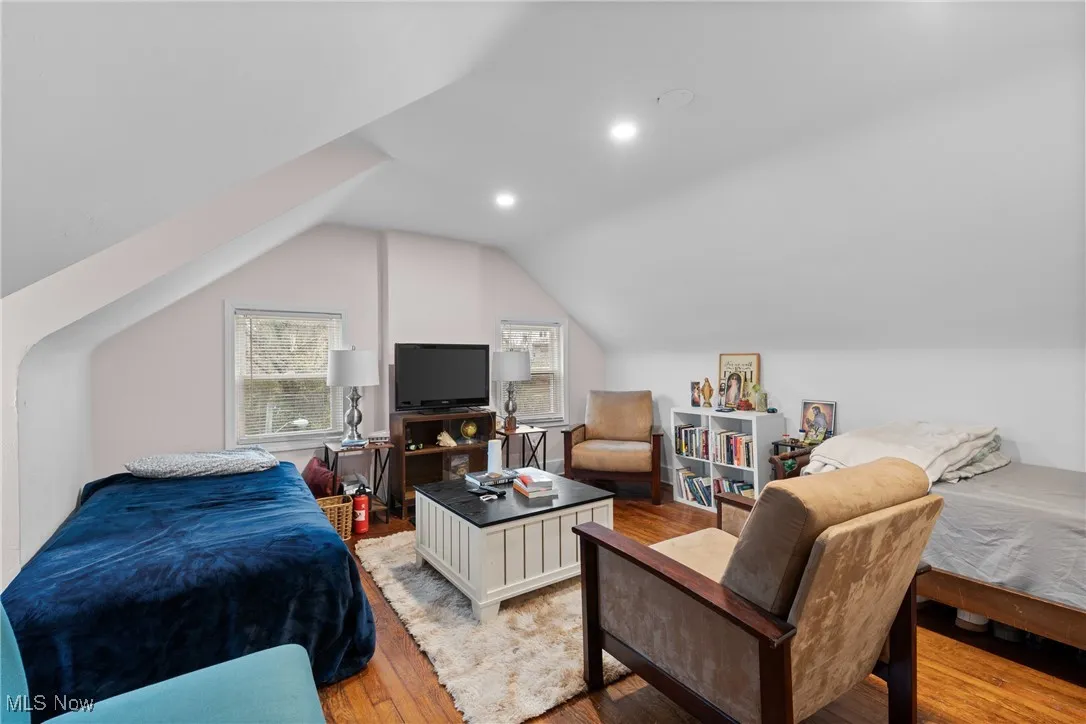 Bedroom featuring multiple windows, light wood-style floors, lofted ceiling, and recessed lighting