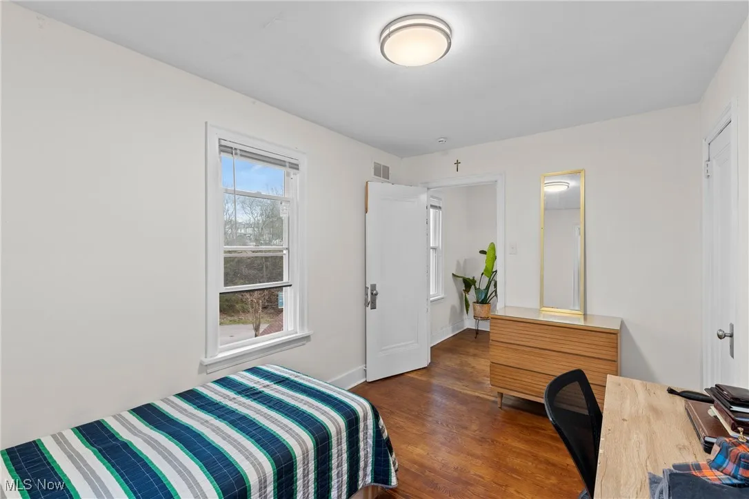 Bedroom with baseboards, visible vents, and dark wood-style flooring