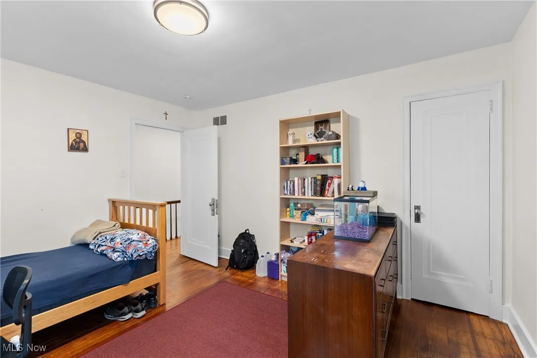 Bedroom featuring dark wood-style flooring and visible vents