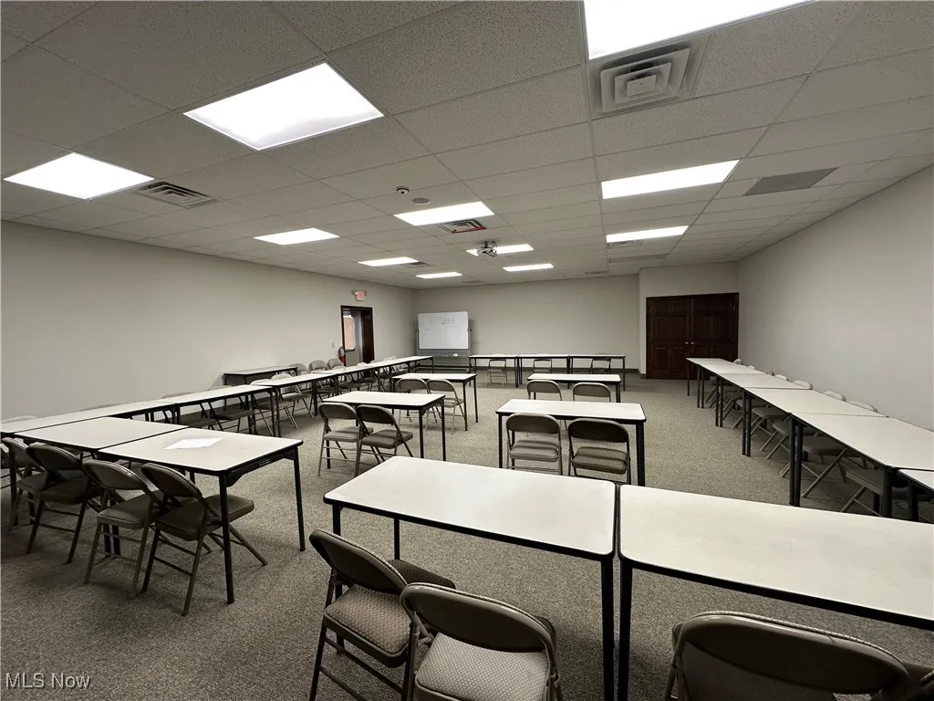 Recreation room with a paneled ceiling, carpet floors, and visible vents