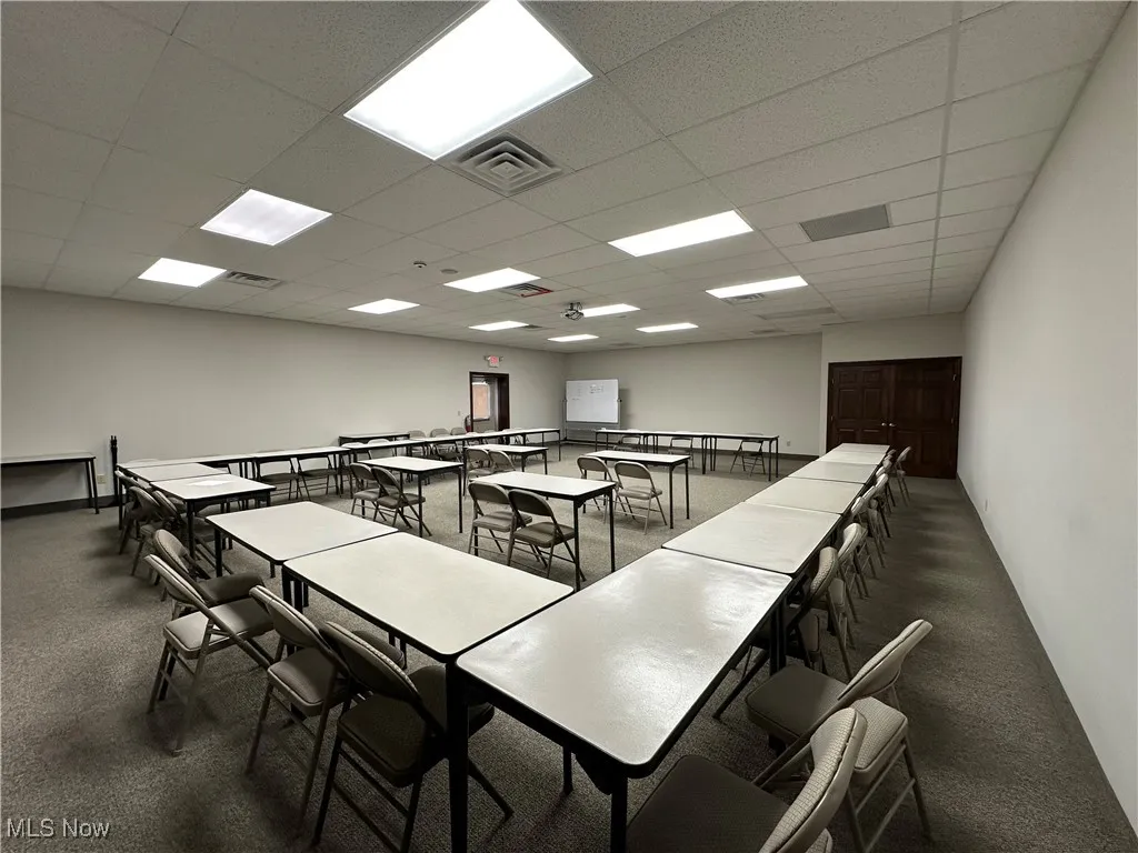 Recreation room with visible vents, carpet flooring, and a paneled ceiling