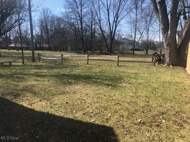 View of backyard featuring a rural view and fence