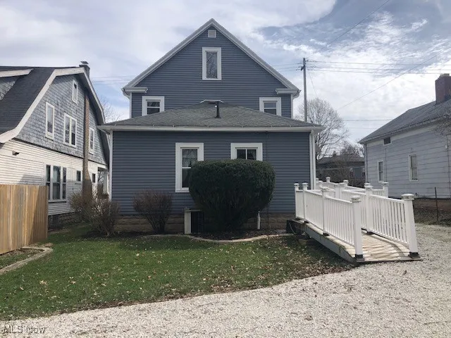 Rear view of house with a wooden deck, a yard, and fence