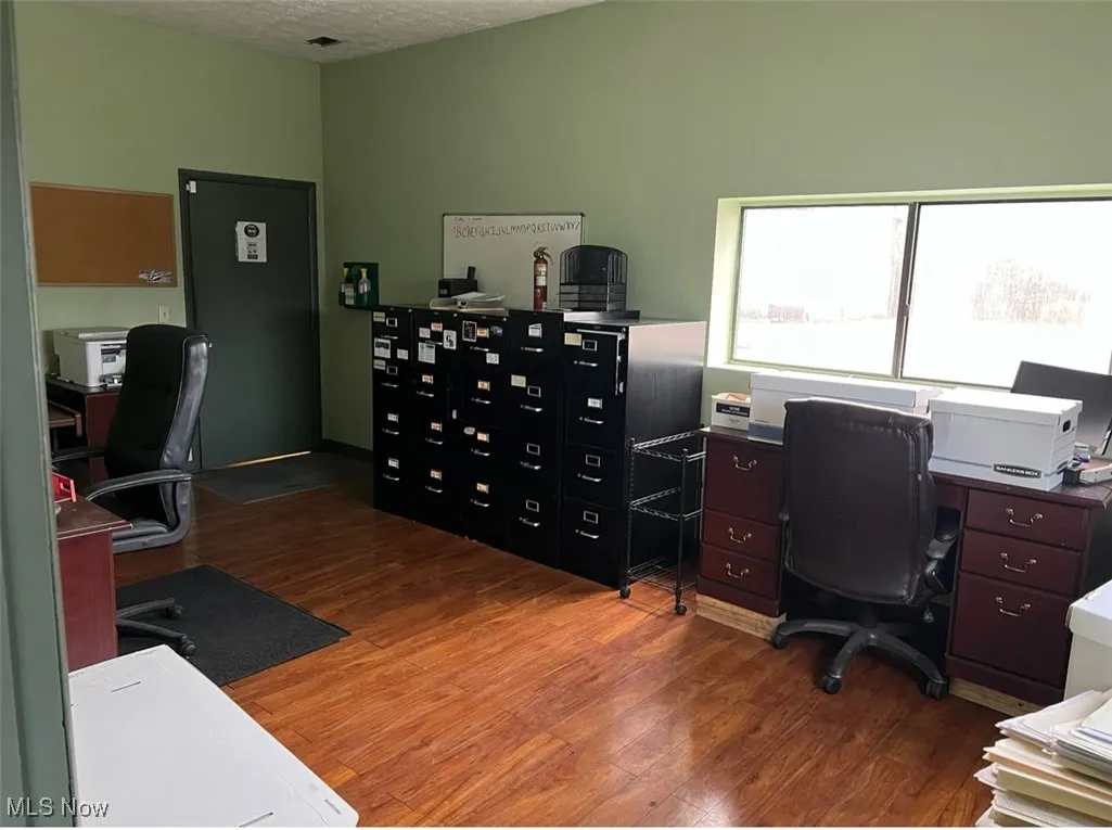 Office area with wood finished floors and a textured ceiling