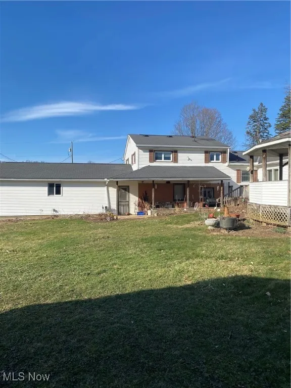 Back of property featuring a lawn