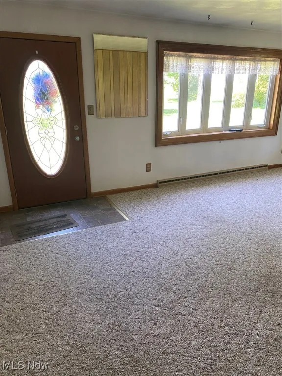 Foyer with plenty of natural light, baseboard heating, and carpet floors