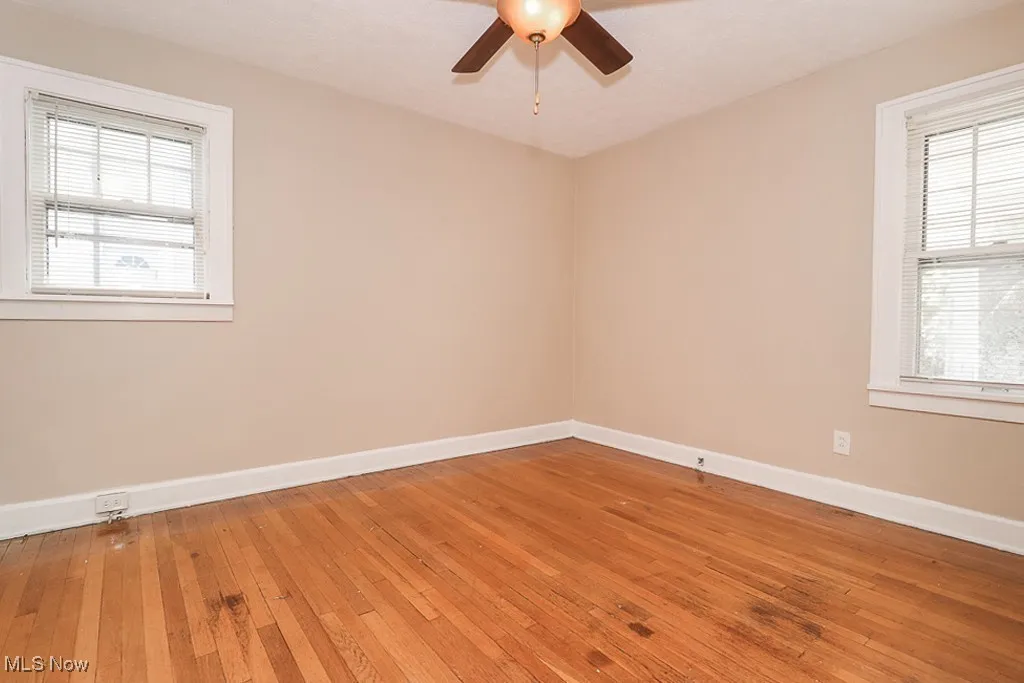 Spare room with baseboards, a ceiling fan, and light wood finished floors