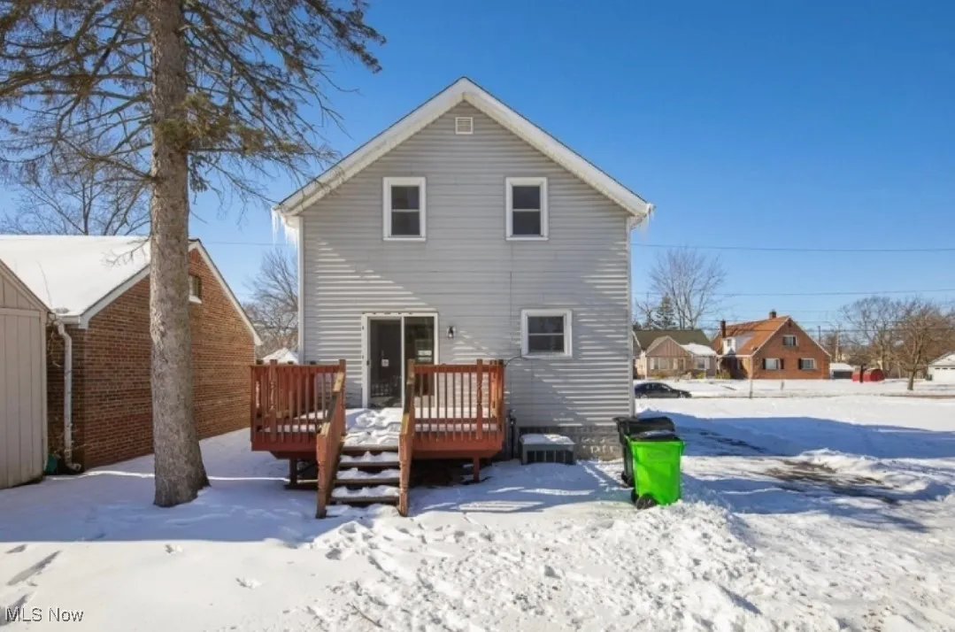 Snow covered rear of property featuring a deck