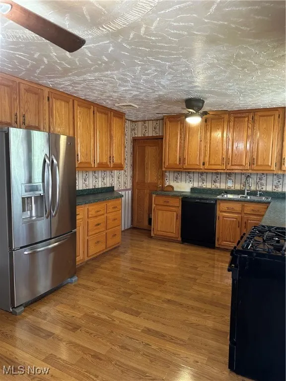 Kitchen featuring refrigerator, dishwasher, a sink, stove, and Amish Built Oak cabinetry