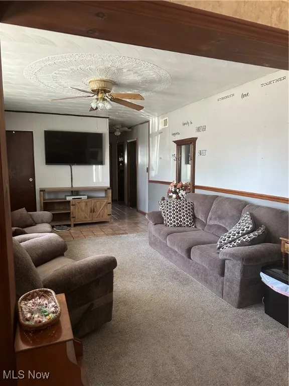 Living area with a ceiling fan and tile patterned floors