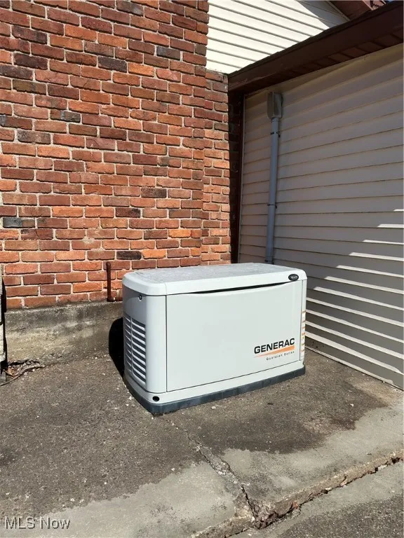 Details featuring a power unit ( Generac) and brick siding
