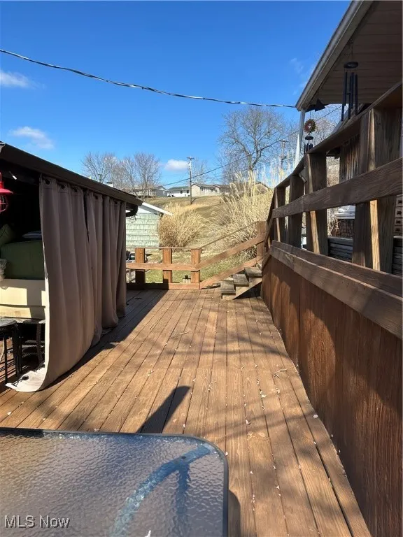 View of wooden deck and she shed