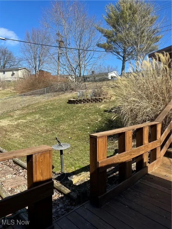 Deck featuring fence and a lawn