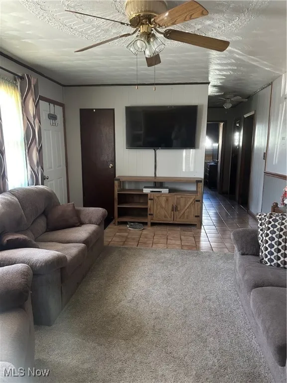 Tiled living area with carpet and ceiling fan