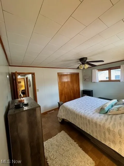 Bedroom with visible vents, a ceiling fan, and dark wood-style flooring