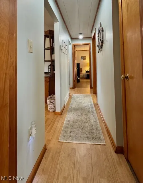 Hall with wood finished floors and baseboards